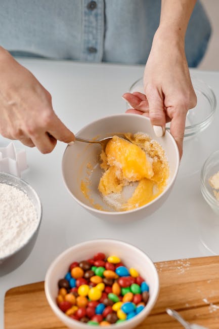 Person measuring and mixing wet and dry dog food during a gradual transition
