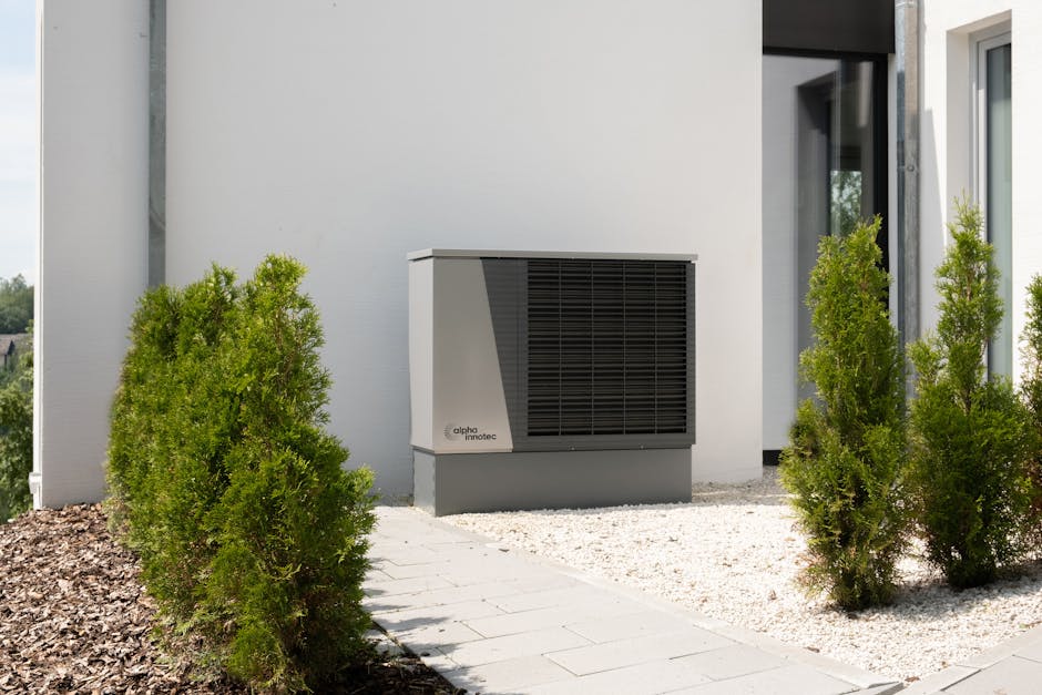 Outdoor monoblock heat pump running at night during cold weather near a home